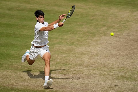 Carlos Alcaraz plays a forehand return to Novak Djokovic